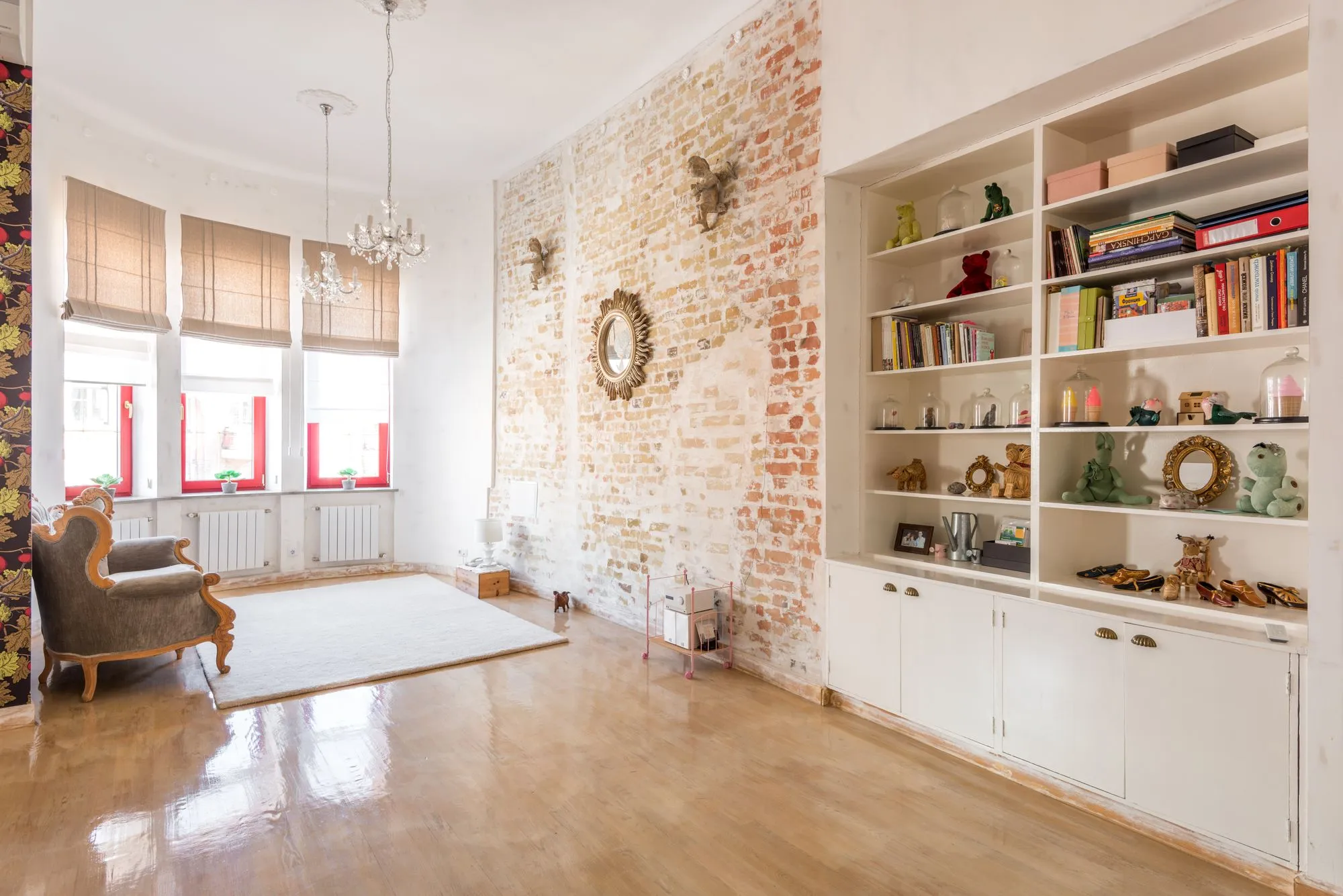 Loft living room with an exposed brick wall, tall windows and built-in shelves